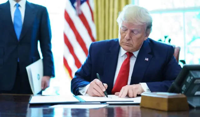 Donald Trump assinando um documento.