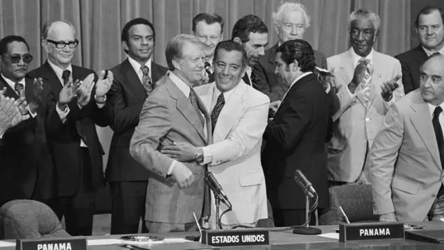 Presidente americano Jimmy Carter e o general panamenho Omar Torrijos celebram a assinatura dos acordos sobre o Canal do Panamá em 1977, ao lado de outras autoridades