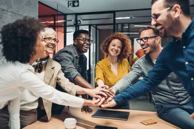 Grupo de colegas comemorando sucesso em uma reunião